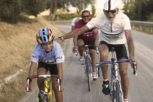 Menschen die Fahrrad fahren, ein Kind und ein Erwachsener im Vordergrund